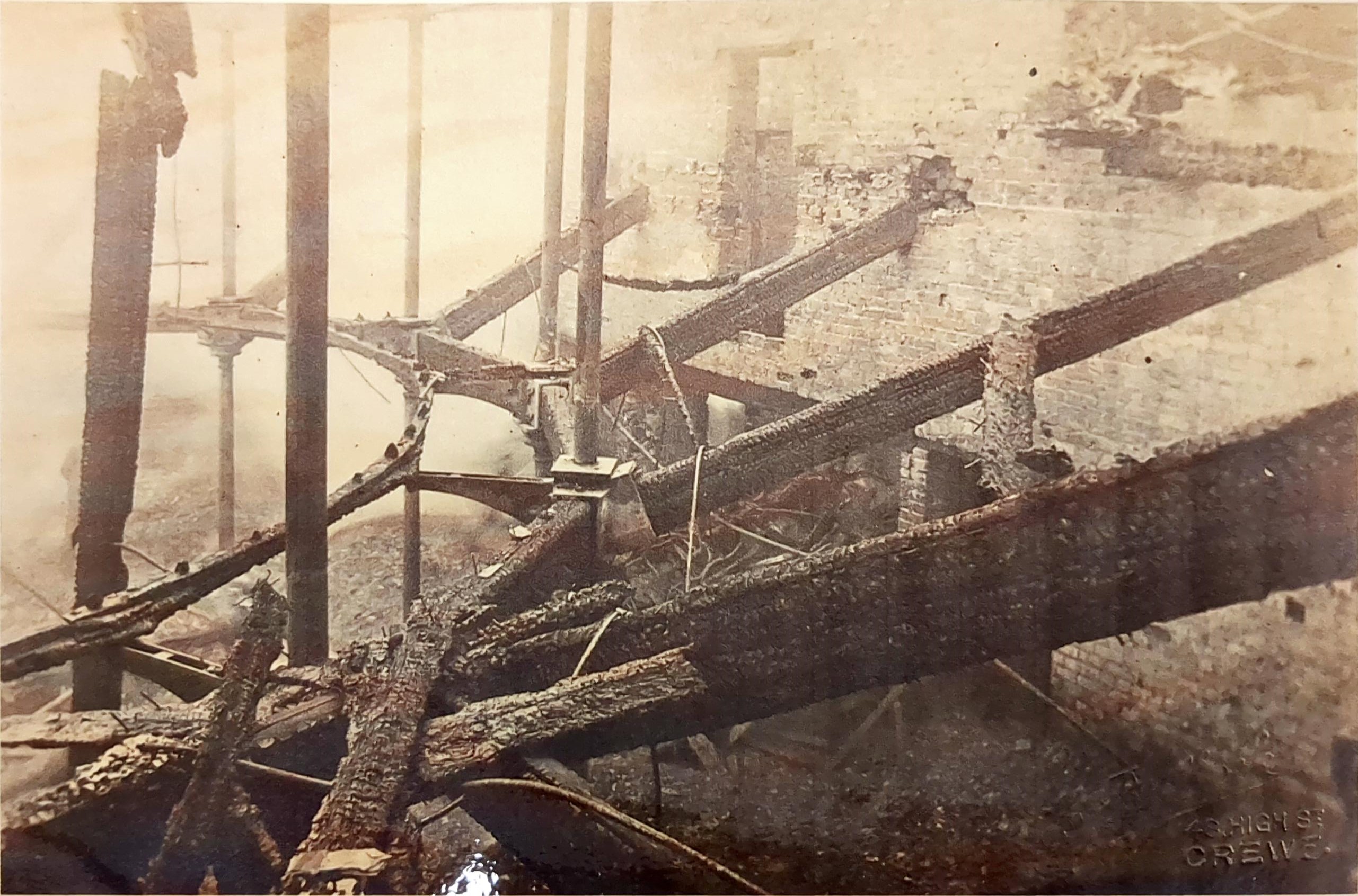 Old photo of the metal frame of the balcony in a burnt out theatre auditorium.