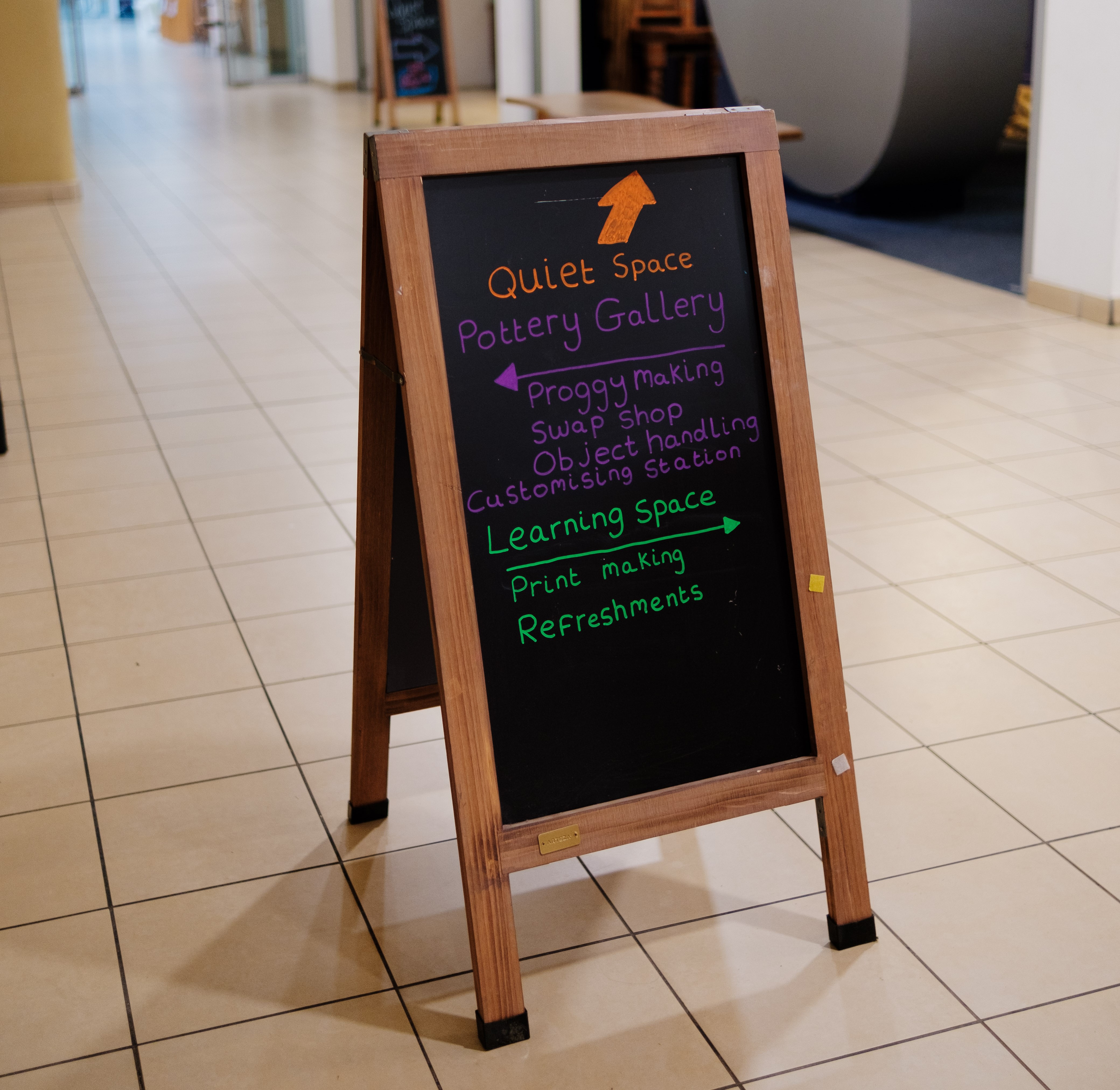 Chalk board sign directing people to different places.