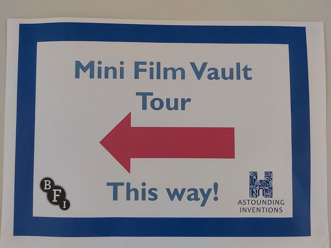 A paper printed sign with an arrow showing the ay to a 'Mini Film Vault Tour' 'This Way'