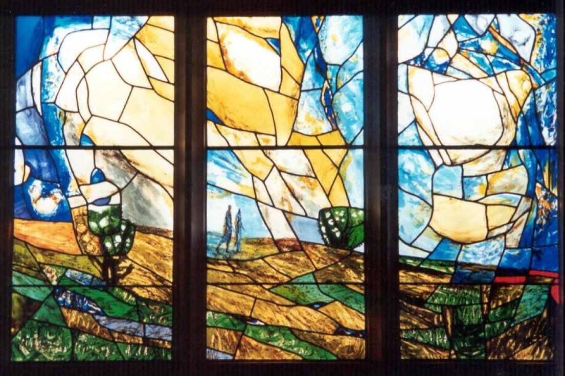 Three brightly coloured stained glass windows depicting two indistinguishable figures walking through a field.
