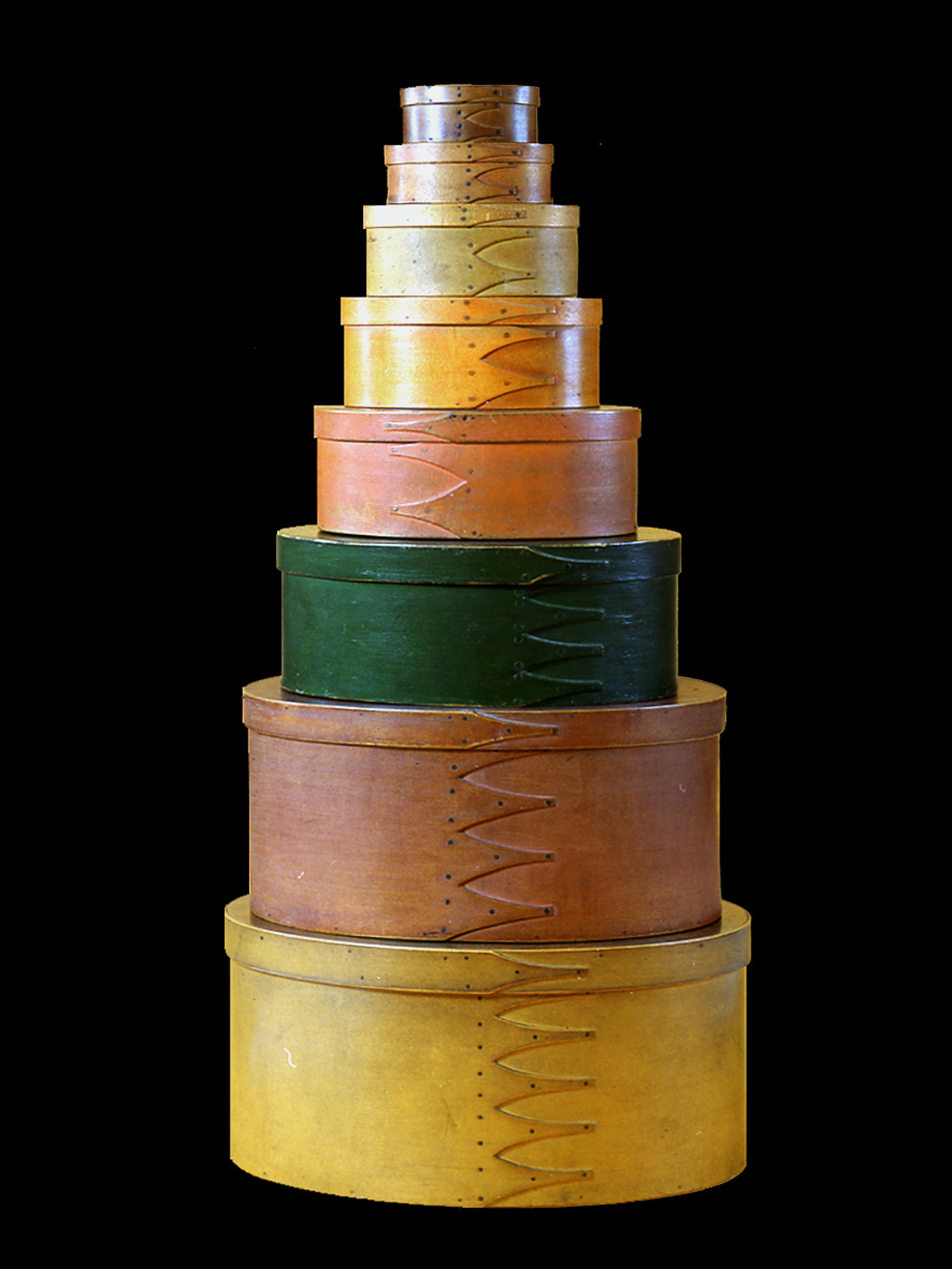 Stack of coloured oval wooden boxes of decreasing size.