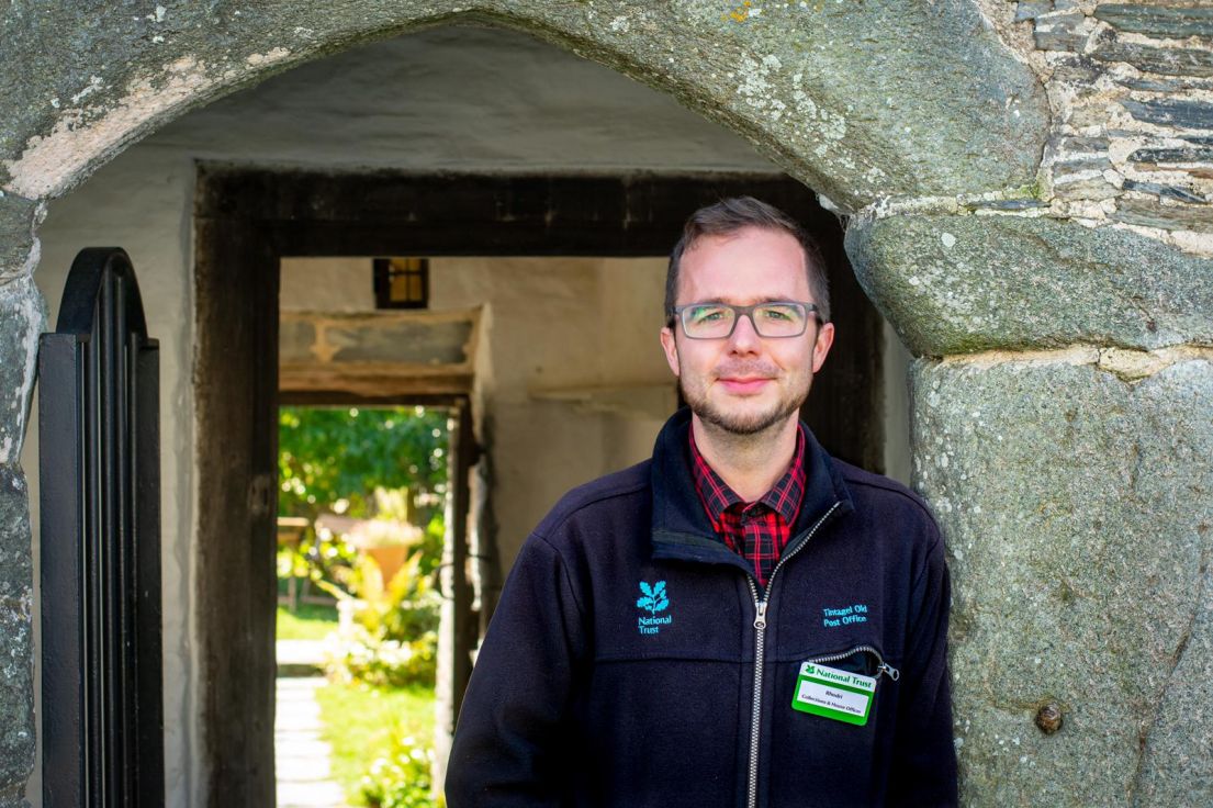 Man in National Trust fleece stood in arched stone doorway