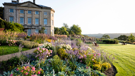 Three-story stone building in beautiful grounds.