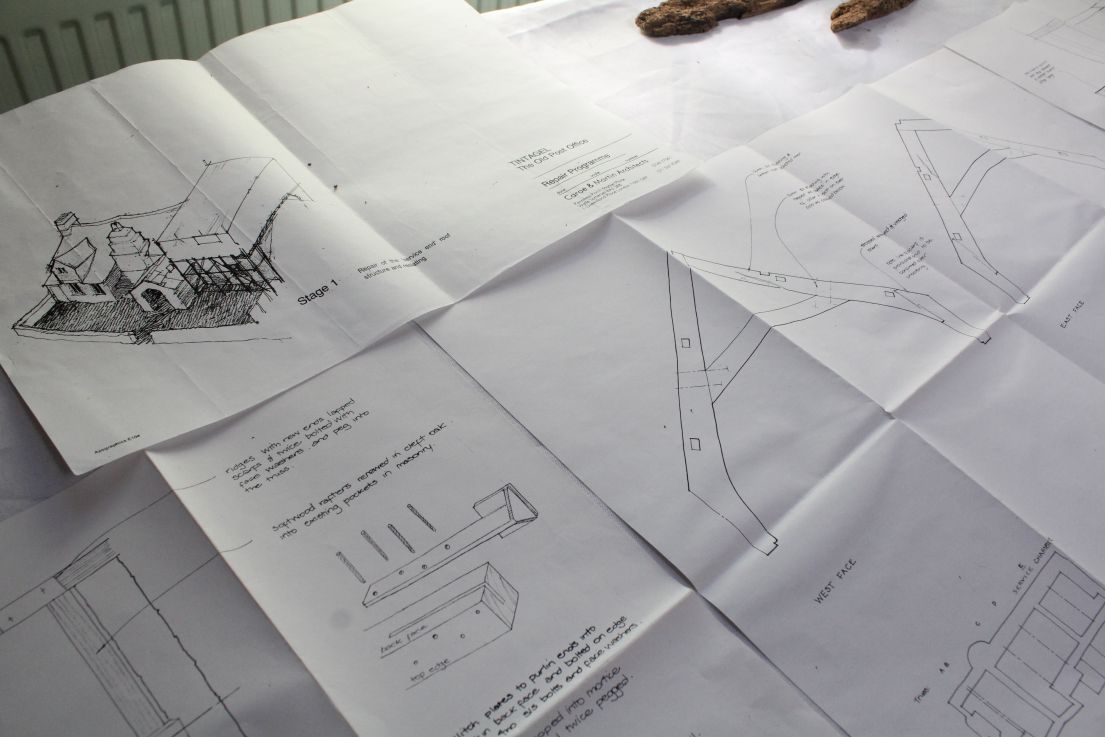 Several architectural drawings and plans scattered on desk