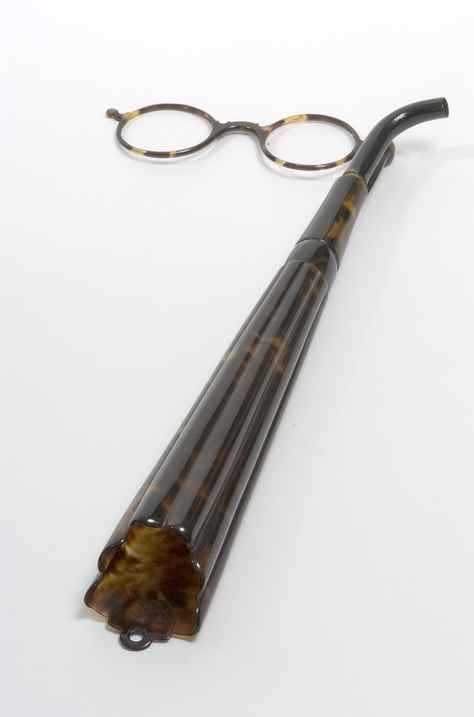 Spectacle frames with a long trumpet shaped earpiece attached.