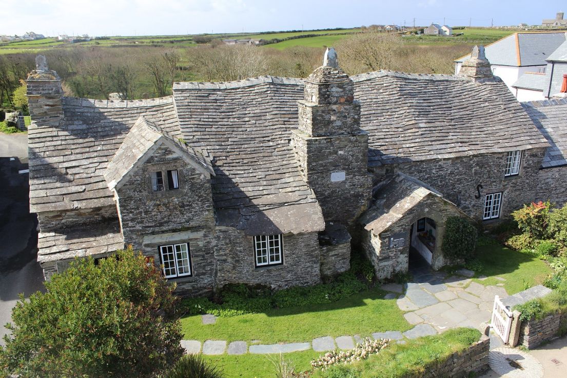 Aerial photograph of a rambling stone building with a wonky roofline