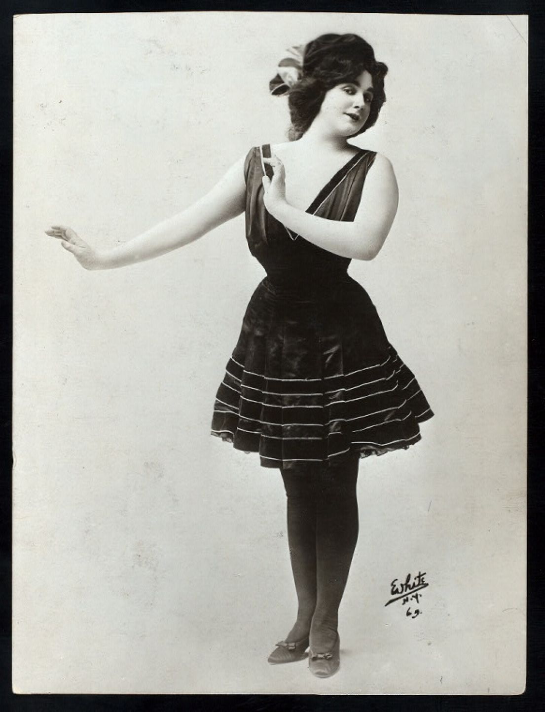 A black and white photo of a famous female impersonator in 1911, wearing a short cocktail dress.